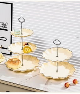 Close-up of a tiered cream yellow petal fruit plate with silver trim and macarons