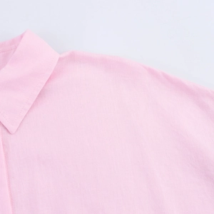 Detail of pink linen shirt featuring a classic turnover collar and fabric texture