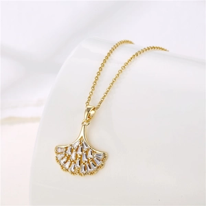 Close-up of gold ginkgo leaf pendant featuring pavé-set shimmering zircon crystals