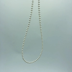 Detail of silver beaded necklace chain with high-gloss finish and adjustable 14k gold link