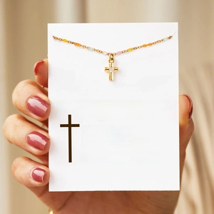 Detail of gold cross necklace with colorful enamel beads on a white message gift card