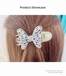 Detail view of a golden butterfly hair claw clip encrusted with sparkling cubic zirconia