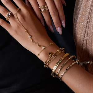 Close-up of 18K gold-plated heart and butterfly bracelets with sparkling zircon stones