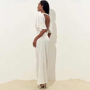 Detail des eleganten weißen rückenfreien Maxikleids mit hohem Schlitz im Minimal-Stil