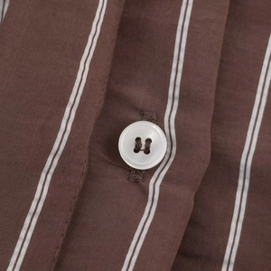 Close-up of brown and white striped shirt fabric with white buttons and stitching