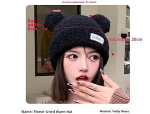Detail view of black teddy fleece earflap hat with cute bear ears and brand label