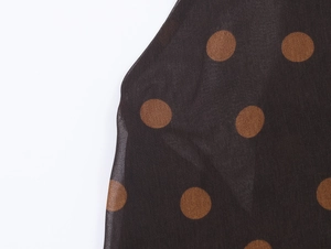 Detailed macro view of polka dot georgette fabric with sheer texture and drape