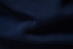 Detailed view of dark blue knit fabric showing tight weave texture and premium material
