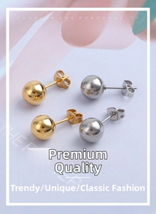 Close-up of gold and silver polished ball stud earrings set with butterfly backings