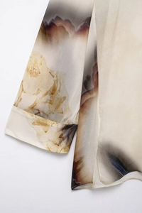 Détail d'un chemisier en satin avec imprimé dégradé et coutures de précision aux manches