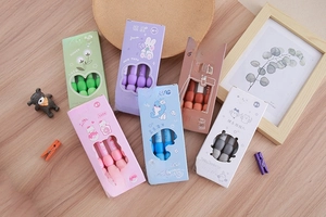 Macro detail of ergonomic soft grip gel pens in pastel colors on a wooden desk