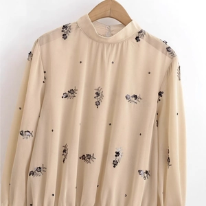 Blouse élégante en mousseline beige à manches longues et broderies florales de paillettes