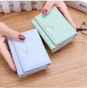 Close-up of light green and blue tri-fold PU leather wallets with heart hardware