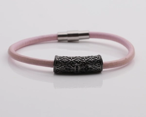 Detail of pink braided leather bracelet with gunmetal cross-engraved magnetic clasp