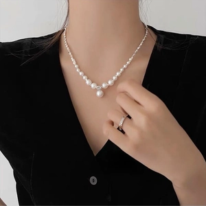 Dettaglio della collana di perle barocche con ciondolo a goccia e anello d'argento