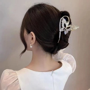 Elegant gold butterfly hair claw clip with pearls and rhinestones on a female hairstyle