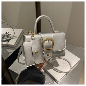 Detail of silver PU leather square bag with metallic D-buckle and golden chain strap