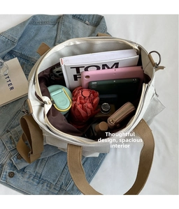 Spacious interior of canvas tote bag filled with daily items like tablet and water bottle