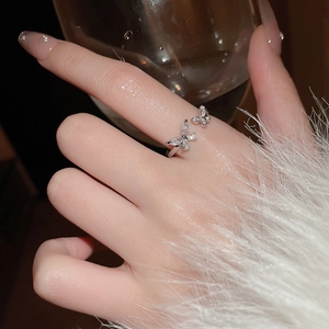 Close-up of elegant butterfly ring with marquise-cut zircons on polished silver band