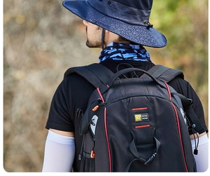 Detail of a black outdoor hiking backpack with red accents and a wide-brimmed sun hat