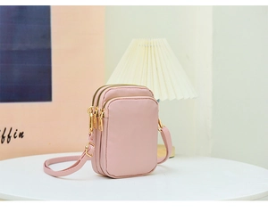 Pink waterproof nylon crossbody phone bag with three zippered compartments and adjustable strap