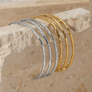 Minimalist geometric line bangles in gold and silver with hammer textured finish