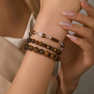 Three-piece tiger eye beaded bracelet set with silver accents on a female wrist