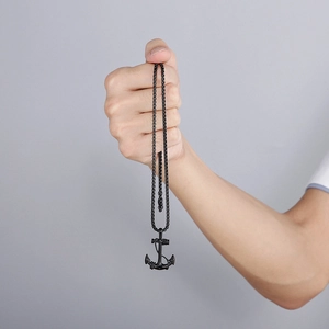 Close-up of black stainless steel anchor pendant with cross detail on box chain