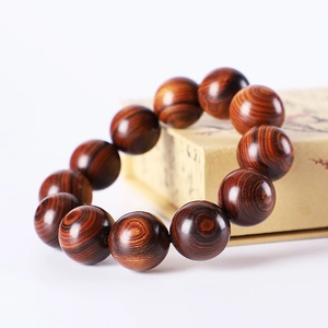 Polished Argentine Green Sandalwood beads on a vintage kraft box background