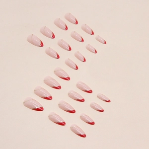Almond-shaped French press-on nails in red and nude with gold glitter ripple detail