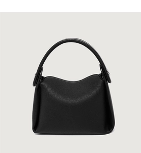Detail of black pebbled leather texture on a minimalist large capacity top-handle bag