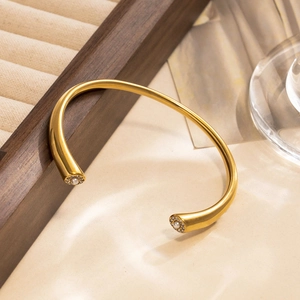 Elegant gold titanium steel open bangle featuring center pearl and rhinestone details