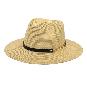 Detail of light beige straw fedora with black leather band and gold chain accent