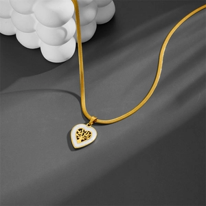Collier cœur arbre de vie doré avec chaîne serpent sur surface grise épurée