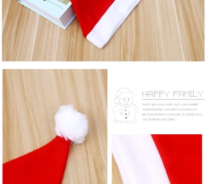 Nahaufnahme der roten und weißen Weihnachtsmützenstoffe und Bommeldetails auf Holz