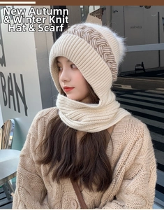 Close-up of knit hooded scarf with white faux fur pom-pom and geometric patterns