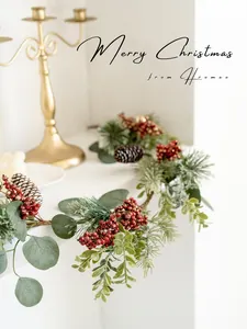 Close-up of Christmas wreath with green pine needles, red berries, and natural pinecones