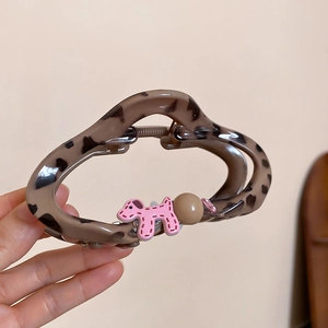 Detail of leopard print hair claw with a pink puppy charm and small sparkling rhinestones