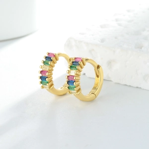 Détail de boucles d'oreilles créoles dorées avec zircons rectangulaires multicolores
