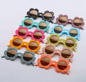 Flat lay of colorful flower-shaped children's sunglasses in ten matte vibrant shades