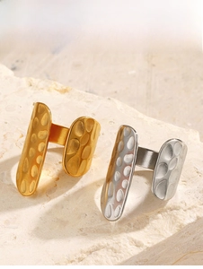 Detail of 18K gold and silver open rings with hammered texture on travertine stone