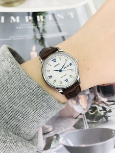 Detail of elegant ladies' watch with leather strap, Roman numerals and calendar display