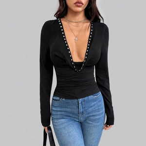 Close-up of black slim-fit long sleeve top featuring a deep V-neck and silver rivet detail