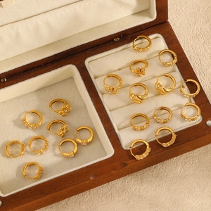Geometric stainless steel gold hoop earrings with zircon stones in a wooden jewelry box