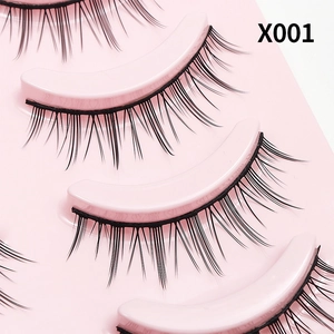 Detailweergave van natuurlijke valse wimpers op roze tray, model X001