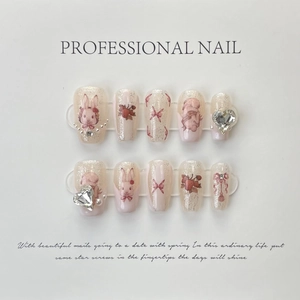 Detalle de uñas postizas degradadas rosas hechas a mano con conejo 3D y diamantes corazón