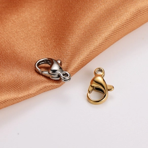Detailed macro of 18k gold and silver stainless steel lobster clasps on silk fabric