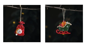 Detail of resin snowman and sleigh ornaments on branches with warm bokeh lighting