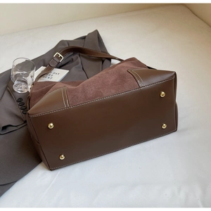 Detail shot of vintage dark brown suede tote bag bottom with protective metal feet