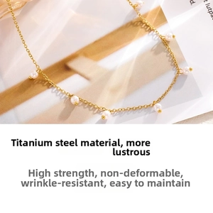 Detail of elegant gold-plated titanium steel necklace with fine chain and pearl accent